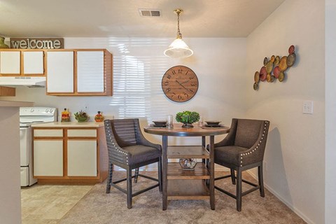 A dining room with a round table and chairs.