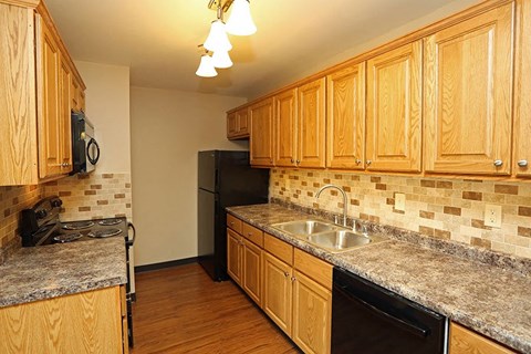 A kitchen with wooden cabinets and granite countertops.