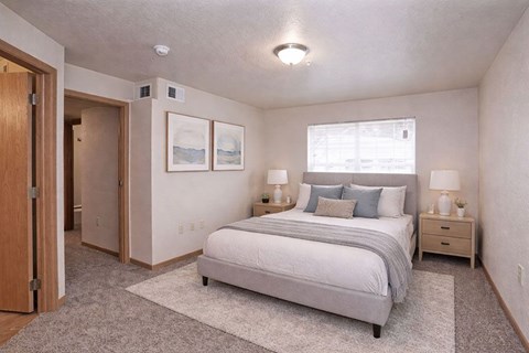 A bedroom with a bed, nightstands, and a rug.