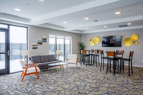 A living room with a grey sofa, a white armchair, and a wooden chair.