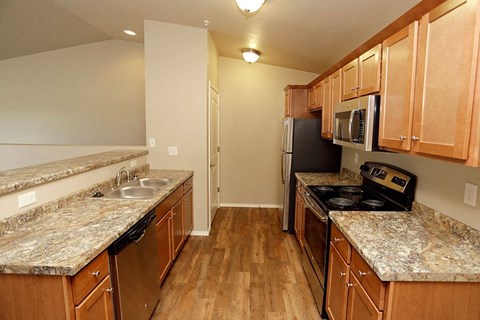 A kitchen with wooden cabinets and granite countertops.