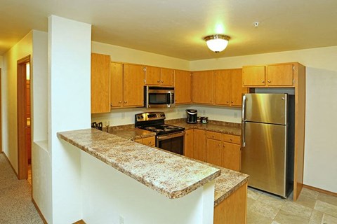 a kitchen with a granite counter top and a stainless steel refrigerator