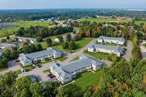 A bird's eye view of a large building surrounded by trees.