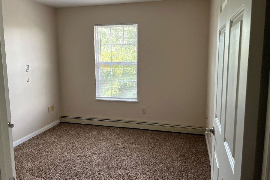 a empty room with a window and carpet