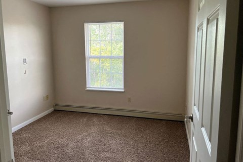 a empty room with a window and carpet