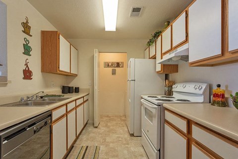 A kitchen with white appliances and wooden cabinets.