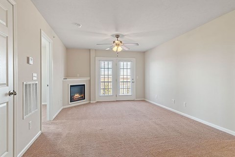 A living room with a fireplace and a ceiling fan.