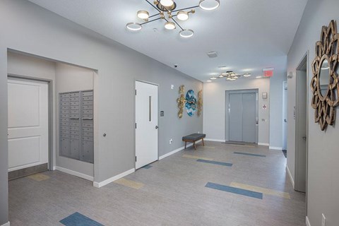 A hallway with a bench, a mirror, and a decorative piece on the wall.