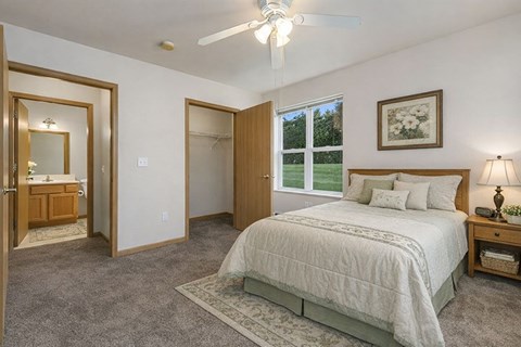 A bedroom with a large bed and a ceiling fan.
