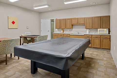 A bedroom with a bed, table and chairs.