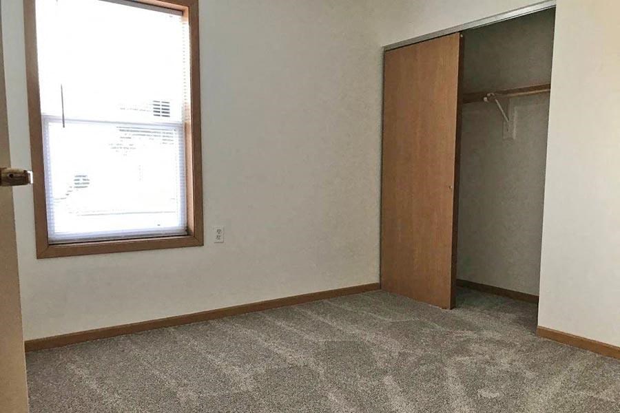 an empty room with a window and a closet