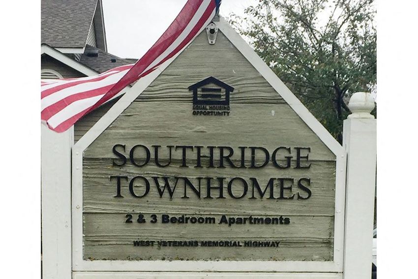 a sign townhomes in front of a flag