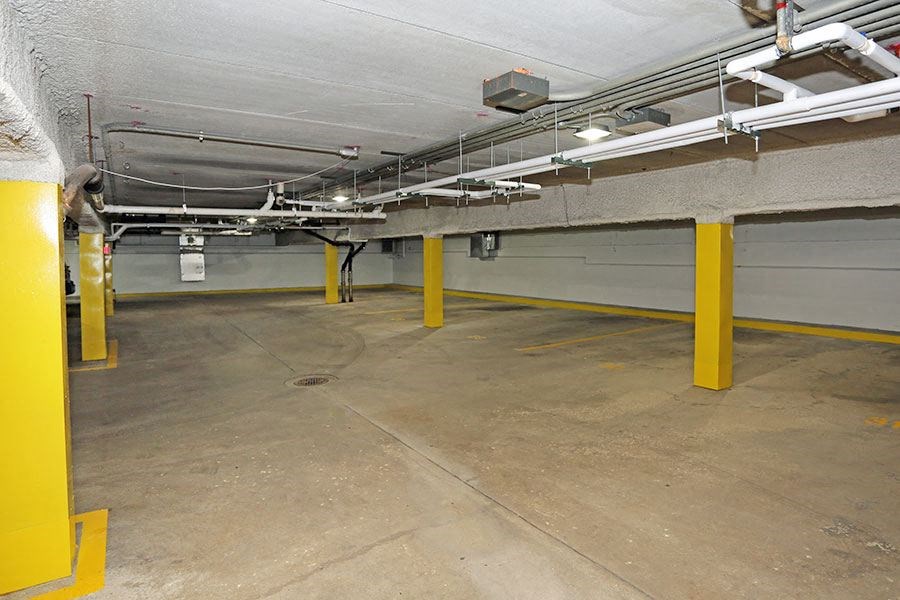 the inside of a parking garage with yellow pillars