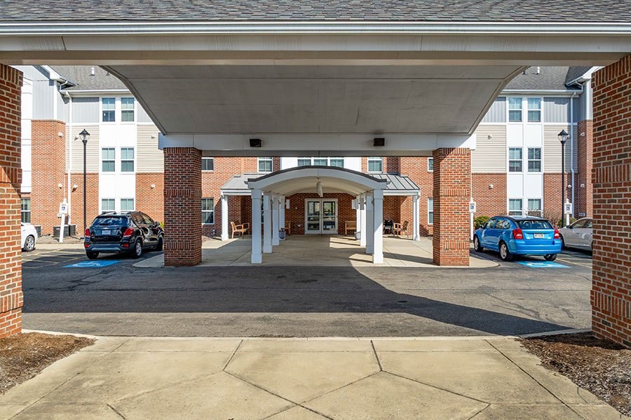 A parking lot with cars and a building entrance.