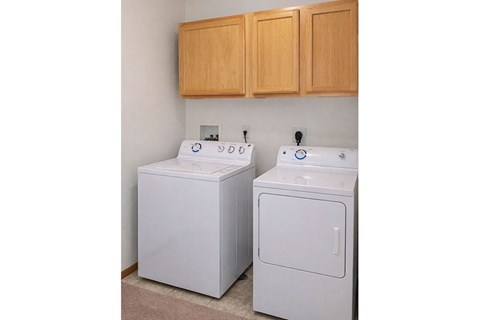 A white washing machine and dryer in a laundry room.