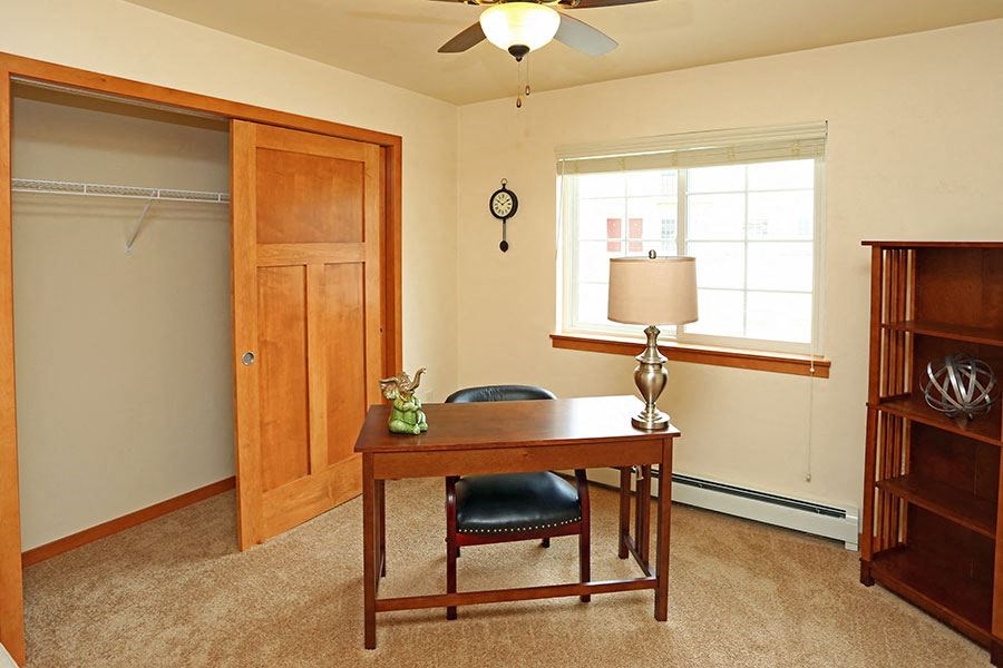 a home office with a desk and a window