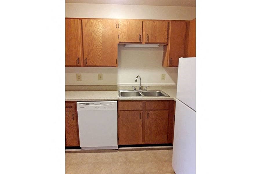 a kitchen with white appliances and wooden cabinets