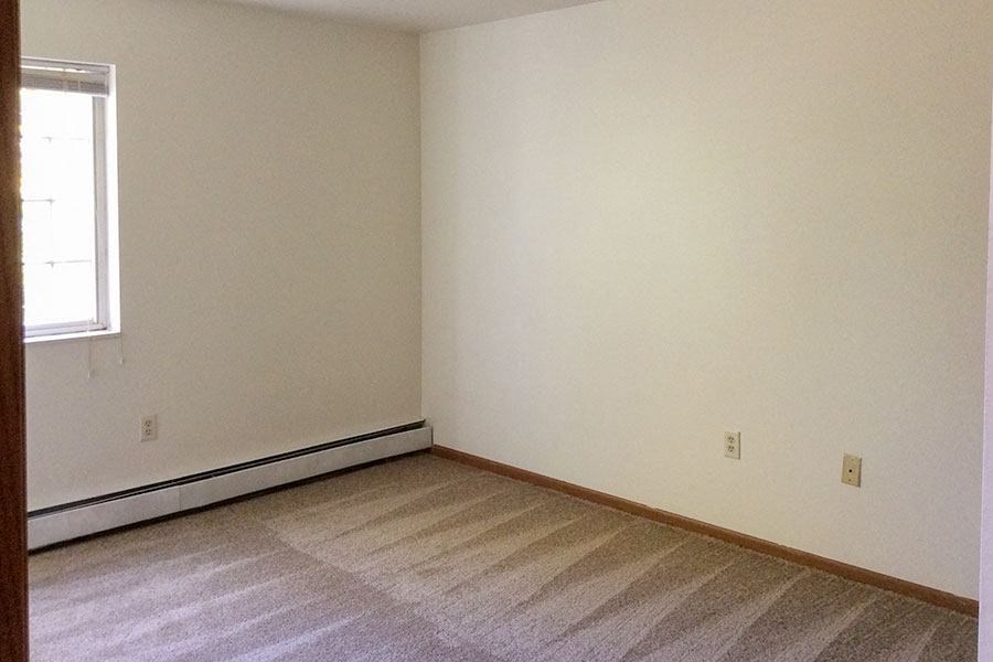 an empty room with white walls and a window