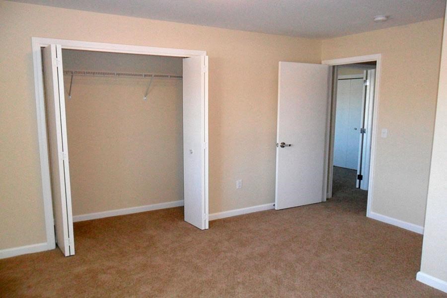an empty room with a closet and an open door