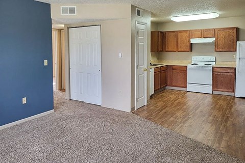 A kitchen with white appliances and wooden cabinets.