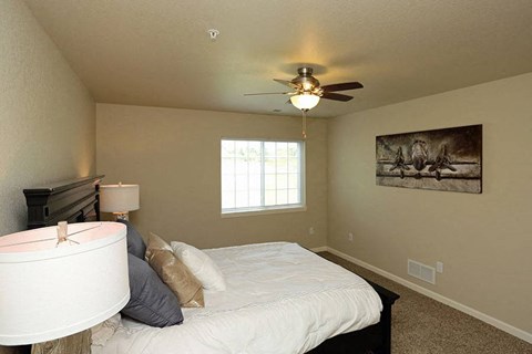a bedroom with a large bed and a ceiling fan