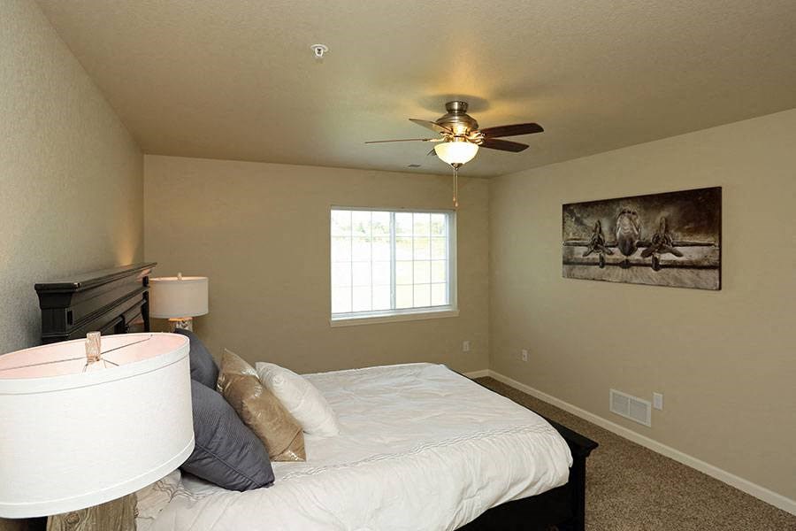 a bedroom with a large bed and a ceiling fan