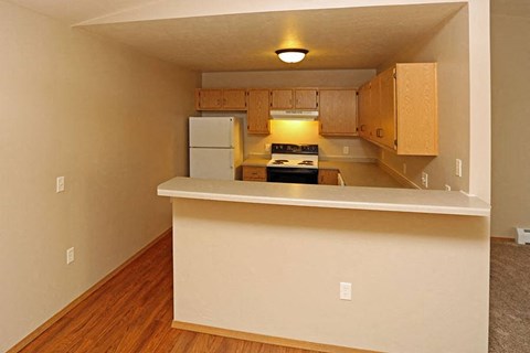 an empty kitchen with a counter and a refrigerator