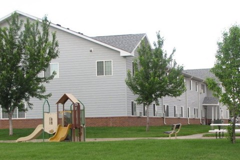 a playground in a yard in front of a house