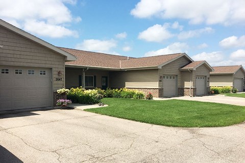 a house with a driveway and lawn in front of it