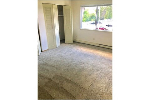 a living room with a large window and a carpeted floor
