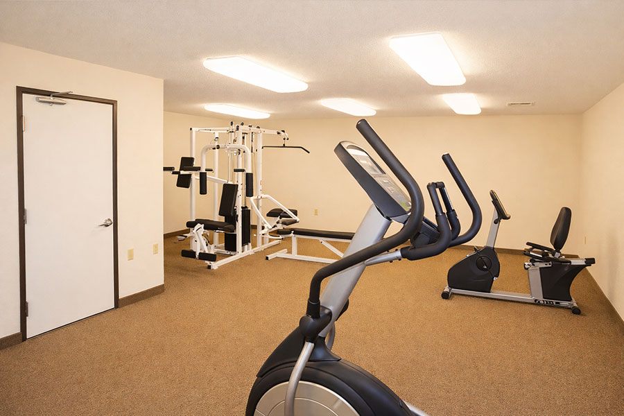 A gym with a variety of equipment including treadmills, weights, and exercise machines.