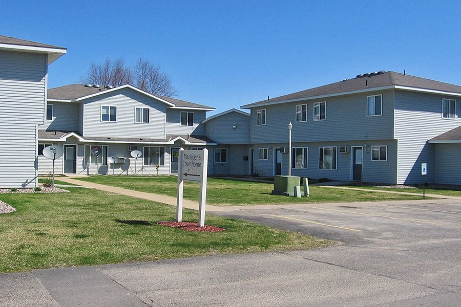 a row of houses with a sign in the grass