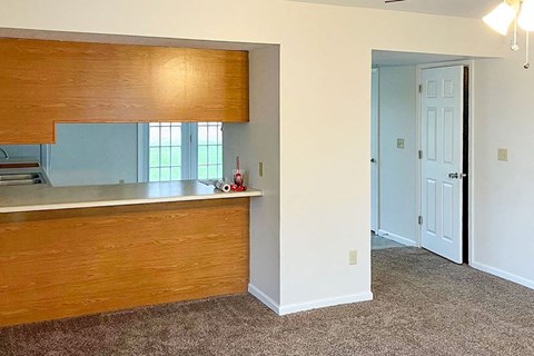 an empty room with a kitchen and a door