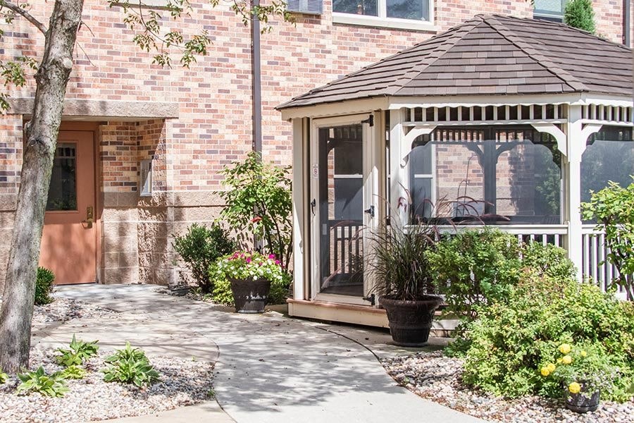 a porch with a gazebo in front of a brick house