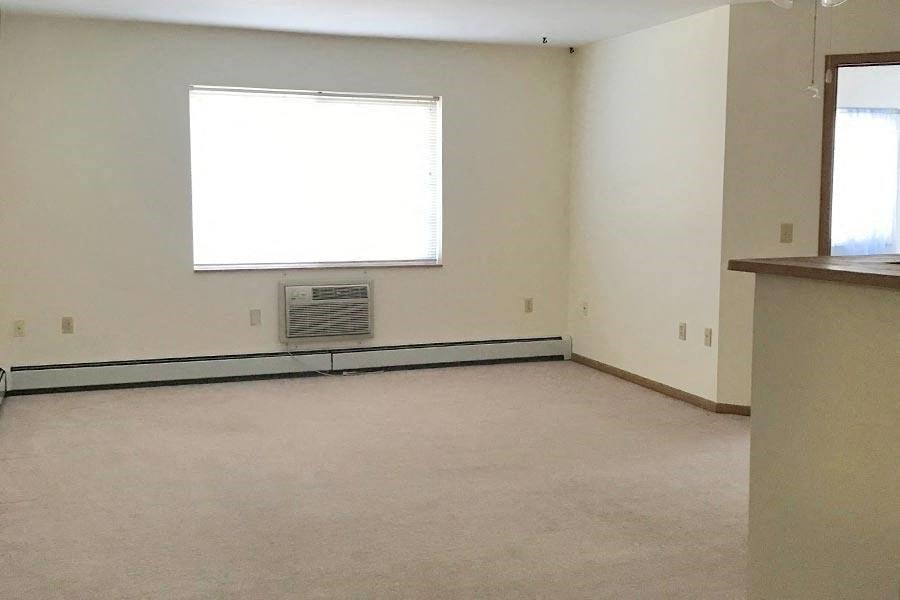 an empty room with a window and a sink