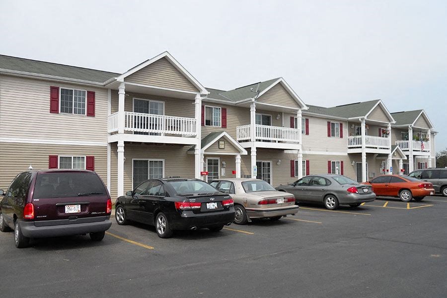 a parking lot filled with cars in front of houses