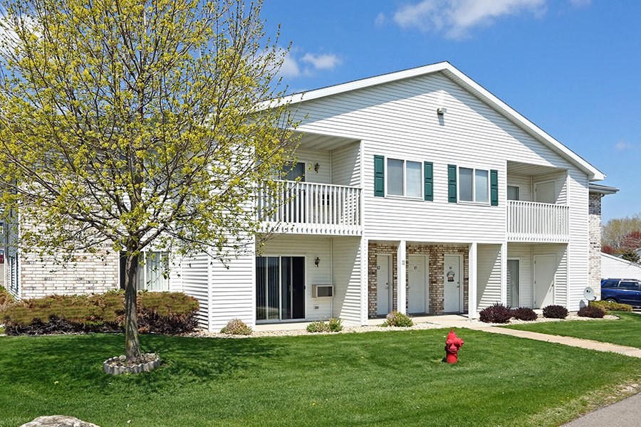 a white house with a red fire hydrant in the yard