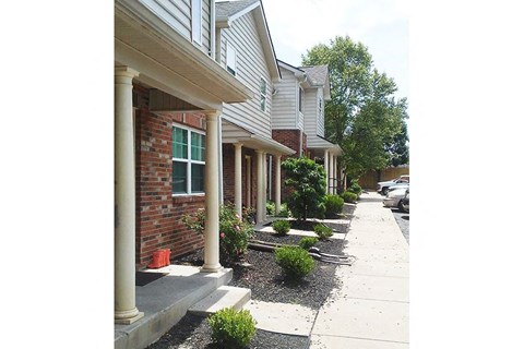 a sidewalk in front of a brick house