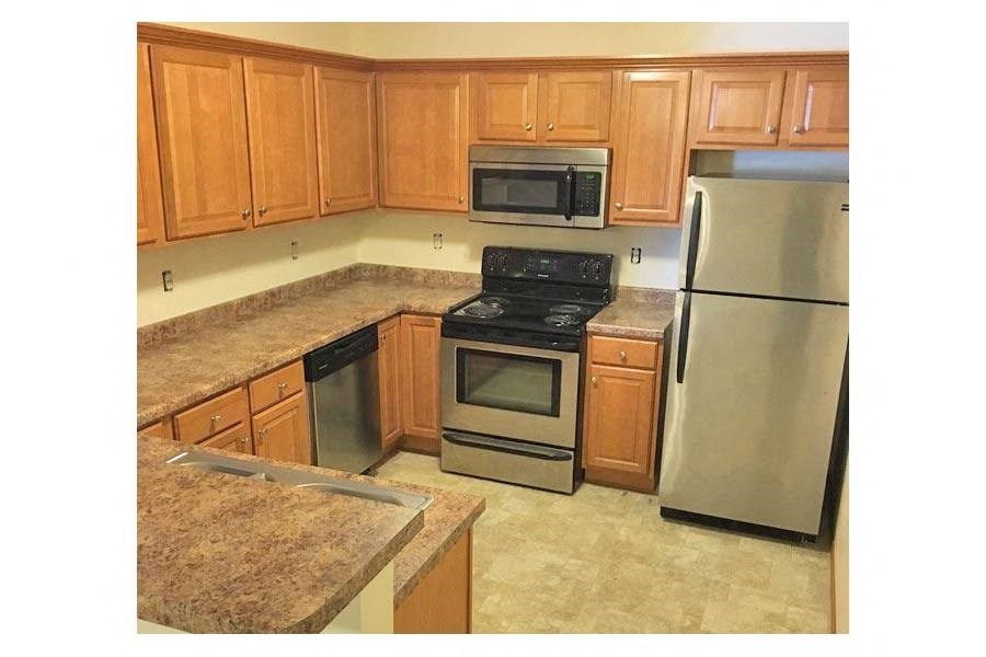 a kitchen with wooden cabinets and stainless steel appliances