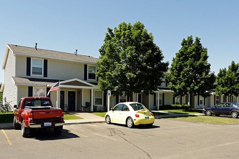 a red truck and a white car parked in front of a house
