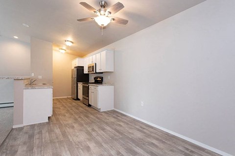 A kitchen with white cabinets and a ceiling fan.