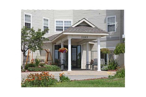 the front porch of a house with a porch swing