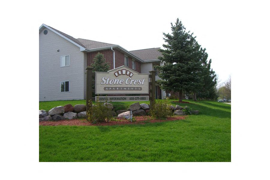 A sign for Stone Crest Apartments is in front of a building.