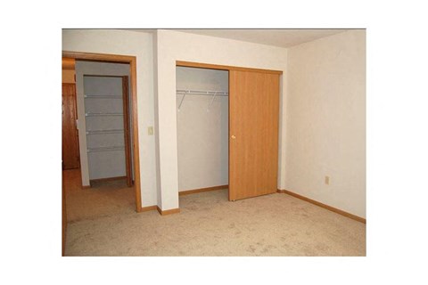 A room with a white wall and a brown door.