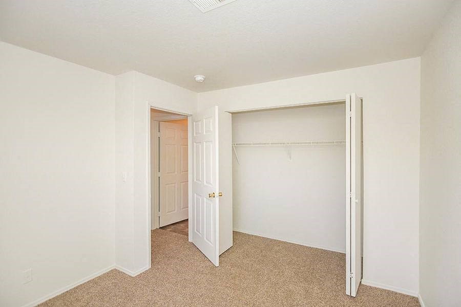 A room with a carpeted floor and a white door.