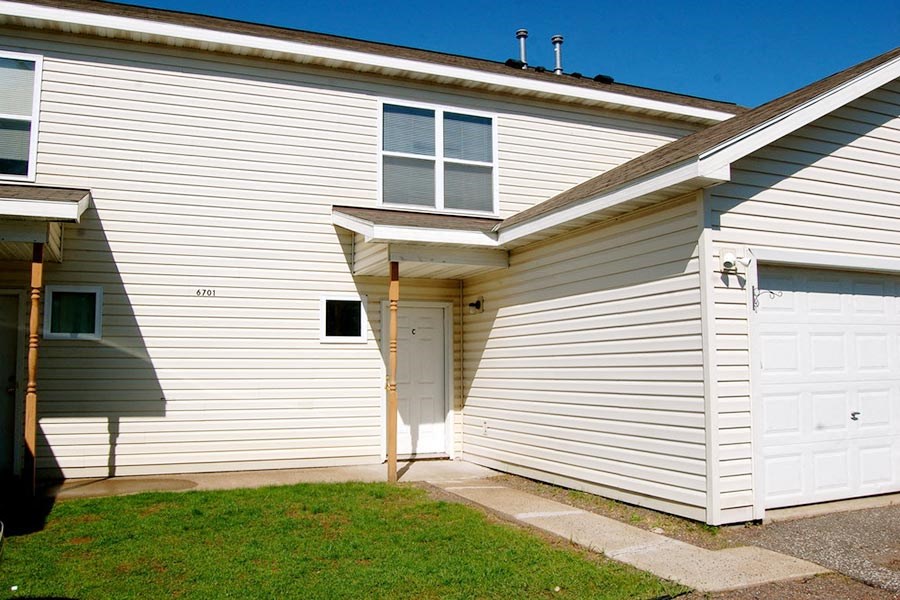 A house with a white garage door and a window on the side.