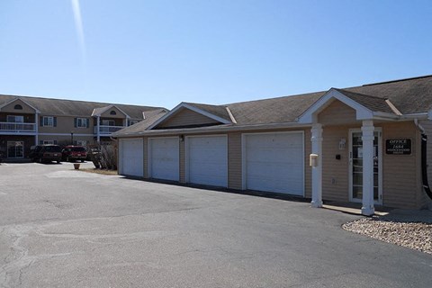 A parking lot with a building and a car parked in front.