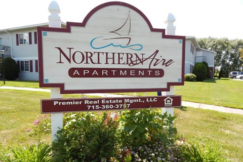 A sign for Northern Aire Apartments with a phone number on it.