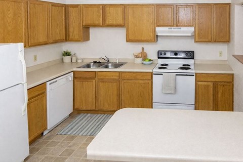 A kitchen with wooden cabinets and a white stove top oven.