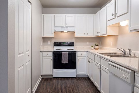 A kitchen with white cabinets and a black oven.